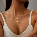 Dettaglio della collana multistrato dorata con tre perle bianche dallo stile elegante - Triplo Strato di Perle / Oro