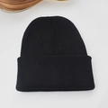 Primer plano de la textura de punto fino y la tela negra de este gorro de invierno cálido - Negro