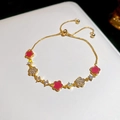 Elegante gouden verstelbare armband met roze bloemen, parels en glimmende zirkoon - Rode Zirconia Bloem