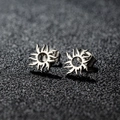 Pair of sun-shaped stainless steel stud earrings with metallic luster on dark background - Flame Sun / Steel