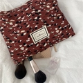 Detail of red-brown crinkle chiffon cosmetic bag with speckle print and pleasant time label - Brown Floral Makeup Bag