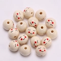 Nahaufnahme von 20mm Naturholzperlen mit aufgedruckten Smileys auf weißem Stoff - Mädchen mit geschlossenen Augen