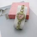 Gros plan d'une montre à quartz cœur rose avec bracelet doré et strass brillants - Or Rose