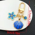 Detalle de dimensiones de los dijes de concha y flor de esmalte azul en el llavero oro - Esmalte Azul Profundo (ER1274)