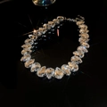 Dettaglio macro della collana di cristallo argento con strass a goccia su fondo nero - Bianco
