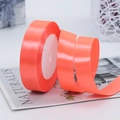 Roll of vibrant coral orange satin ribbon for gift wrapping with silky texture and glossy finish - Fluorescent Red