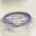 Nahaufnahme von lila Silikonarmband mit strassbesetztem silbernem Metallrohr - Hellviolett
