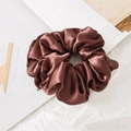 Brown satin scrunchie with silky texture shown on white background with stationery items - Red Brown