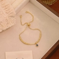 Dettaglio del bracciale regolabile con perline dorate, malocchio e barra di strass - Stile Barra Orizzontale (I)