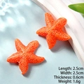 Dettaglio di due stelle marine in resina arancione con trama bionica e misura 2,5 cm - Stella Marina Arancione Cicciotta