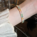 Detail eines farbenfrohen rechteckigen Zirkon-Tennisarmbands mit Goldfinish am Handgelenk - Gold Bunt Quadrat