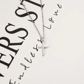 Polished stainless steel cross pendant necklace with classic chain on minimal white card - Steel