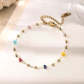Dettaglio bracciale a catena dorata con perle colorate e chiusura a moschettone sicura - Bracciale A Catena A Cubo Con Pietre Multicolore / Oro