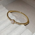 Elegant gold oval zircon bracelet featuring rectangular crystals on a gray velvet box - Gold