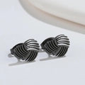 Detailed view of matte black geometric spiral stud earrings with unique swirl texture - Black