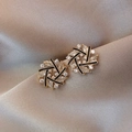 Gold snowflake earrings with clear zircon stones on champagne silk fabric background - Black Hollow Ice Flower Studs / Gold