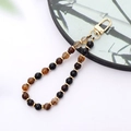 Close-up of beaded phone strap with natural agate stones and golden metal clasp - K3414 Striped Agate Natural Stone Pendant