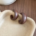 Close-up of ethnic style dark brown wood hollow flower round pendant earrings on a tray - Silver Earring Post - Coffee