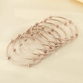 Vista dettagliata di sette bracciali sovrapposti in oro rosa con perle su sfondo di seta - Diametro interno 60mm / 7 Anelli / Oro rosa