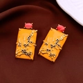 Détail de boucles d'oreilles vintage avec motifs floraux dorés et clous roses - Style Fleur de Prunier Jaune