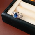 Detail of an oval blue gemstone ring with zircon accents in a black jewelry box - Silver-Blue-Oval