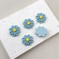 Macro detail of blue resin flower charms with yellow center for DIY crafts decoration - Light Blue