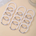Detail of white polymer clay bracelets with BE KIND letter beads and gold metal spacers - White
