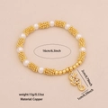 Golden beaded bracelet with seahorse pendant featuring white pearls and copper material - Seahorse