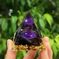 Orgone pyramid with amethyst ball and obsidian stones held in hand over natural background - Style 16