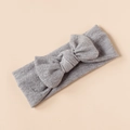 Detail shot of a grey knitted baby headband with a prominent soft textured bow - Gray