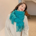 Close-up of soft turquoise winter scarf with fringe details worn by a model - Teal