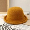 Detailed close-up of mustard yellow knitted bucket hat with textured rolled brim design - Orange
