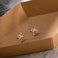 Detailed view of hollow rabbit silver earrings on a brown hexagonal jewelry tray - Hollow Rabbit / Silver