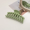 Macro view of matte avocado green large hair claw clip on a minimalist background - Keel / Bean Green