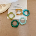 Detailed close-up of colorful resin rings with marble texture on vintage fabric - Green Set (Five Pieces)