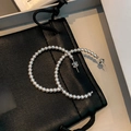Elegant C-shaped hoop earrings featuring small white pearls on a black leather pouch - Silver Needle - White - 4mm