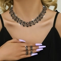 Dettaglio di modella con set di collana e orecchini in rete nera e oro lucido - Nero Argento