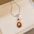 Detail of irregular amber resin pendant with beads on brown cord necklace shown on card - 14# Necklace-Coffee