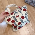 Close-up of a floral cotton handbag being held to show its size and soft canvas texture - Red Rose