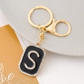Detailed view of golden S-letter keychain with inlaid rhinestones and lobster clasp - S