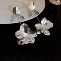 Dettaglio di orecchini a fiori argentati con doppio petalo e finitura in metallo lucido - 夸张花朵镜面款式(33#)