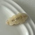 Vue détaillée d'une barrette à cheveux ondulée en acétate marbré avec clip doré - Poche zippée