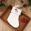 White knitted Christmas stocking with red embroidered letter A and festive berry pattern - Letter A
