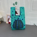 Cute mint green knitted wrist bag featuring blue polka dot pumpkin design - Pumpkin Green