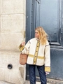 Close-up of quilted cream jacket with olive green trim and classic button detailing - Apricot