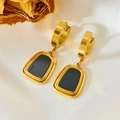 Détail de boucles d'oreilles dorées avec pendentifs rectangulaires noirs sur soie blanche - Boucles d'Oreilles Créoles en Coquille Noire