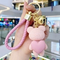Pink resin bear keychain with knitted texture holding a heart and gold bell pendant - Pink