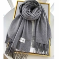 Elegant grey cashmere-feel scarf with tassels and brand label on a stylish background - Medium Grey