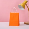 Detail of orange kraft paper party gift bag with white twisted rope handle and sturdy base - 15*11*6 / Orange