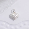 Macro shot of silver heart pendant with refined grid texture on white silk background - Silver Grid Pattern Heart Pendant